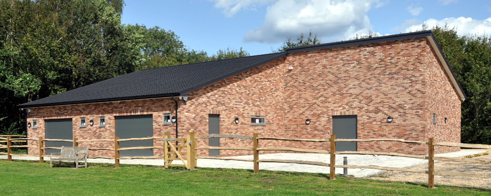A single-storey brick building with large grey doors and very small windows